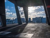 a street view of several huge structures and sky in the background with sun peaking through