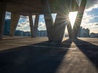 the sun shines brightly through a set of columns on the roof of an urban building