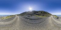 the sun shines over a beach area in this fish - eye picture made from some rocks