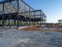 a picture of a building being built on a field near a forest in the background