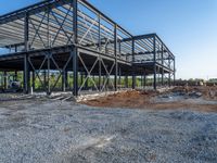 a picture of a building being built on a field near a forest in the background