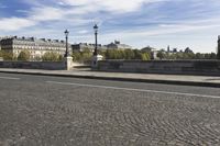 two people are riding bikes on the bridge by the street light of an old european city