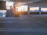 a parking lot with stairs and steps leading up to a balcony area at sunset next to some steps