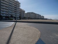 the empty beach and paved walkway in front of the buildings on the beach and a bus stop