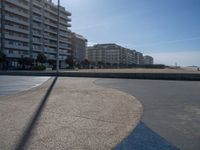 the empty beach and paved walkway in front of the buildings on the beach and a bus stop