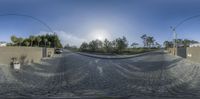 a panorama of an intersection of cobblestones in the foreground with the sun shining on the horizon