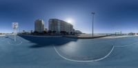 a skateboarder that is doing tricks in a city park, using the fisheye lens