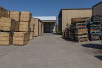 a warehouse area with stacked up wicker boxes and pallets outside a warehouse area