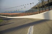 the drivers drive on a track next to an artificial wall, with lights around it