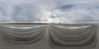 a spherical 360 - view image of a racetrack with blue and white lines on the pavement