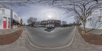 a 360 - view photo of a street with cars on the road near buildings in a neighborhood