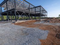 a picture of a building being built on a field near a forest in the background