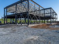 a picture of a building being built on a field near a forest in the background