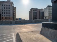 several large empty parking spaces in the city with buildings nearby in front of them -