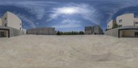 a panoramagraph looking outside at a skateboard park in a skate park area on a sunny day