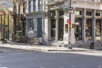 an intersection with buildings and a street light on a sunny day in the city,
