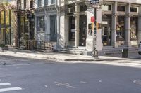 an intersection with buildings and a street light on a sunny day in the city,
