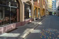 a city street with tables and chairs painted in a colorful tile pattern on the sidewalk