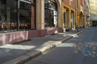 a city street with tables and chairs painted in a colorful tile pattern on the sidewalk