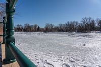 an image of the frozen river in winter time on a sunny day, looking out to the water