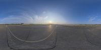 the sun shining down on a cloudless sky above an airport tarmac with some yellow cars