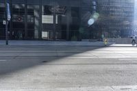 a man riding a bike past buildings on the side of the road in front of a fire hydrant