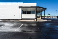 an empty parking lot with no people inside it and a man walking to the building