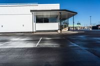 an empty parking lot with no people inside it and a man walking to the building