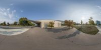 a 360 - view of a skate park and a bench area on a sunny day