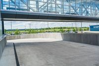 an empty parking area outside a large building that is under construction with windows on top