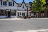 a town street that is surrounded by houses and businesses on a sunny day with blue skies