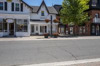 a town street that is surrounded by houses and businesses on a sunny day with blue skies