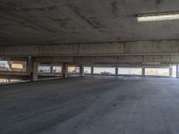 an empty parking garage with several windows overlooking the landscape of a small town where there are tall buildings