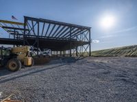 a picture of a building being built on a field near a forest in the background