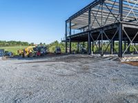 a picture of a building being built on a field near a forest in the background