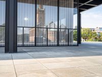 a view of the clock tower out of a glass building on a sunny day in an open courtyard