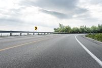 there is a road that has been paved with two lanes and a bridge behind it