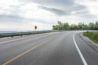 there is a road that has been paved with two lanes and a bridge behind it