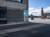 an empty street with the reflection of a building on it in between the road and sidewalk