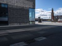 an empty street with the reflection of a building on it in between the road and sidewalk