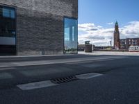 an empty street with the reflection of a building on it in between the road and sidewalk