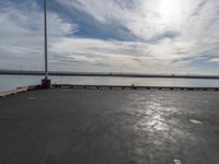 the dock and the water from which one is parked on the pier, with a bird flying in the distance