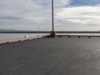 the dock and the water from which one is parked on the pier, with a bird flying in the distance