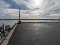 the dock and the water from which one is parked on the pier, with a bird flying in the distance