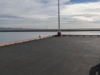 the dock and the water from which one is parked on the pier, with a bird flying in the distance