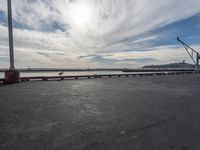 the dock and the water from which one is parked on the pier, with a bird flying in the distance