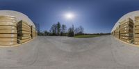 two fisheyes that are looking at stacks of wood crates behind them, and a road in the middle