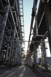 a factory with some pipes and scaffoldings at sunset time near the city