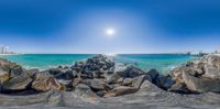 the view of a beach through a fish eye lens lens on the rocks next to the ocean