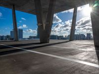 an open parking lot with sun shining through windows and a view of the city below